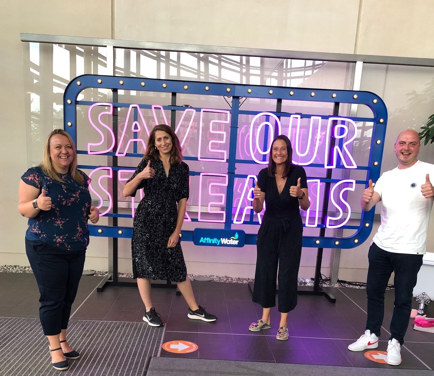 Save Our Streams team standing in front of the Save Our Streams sign