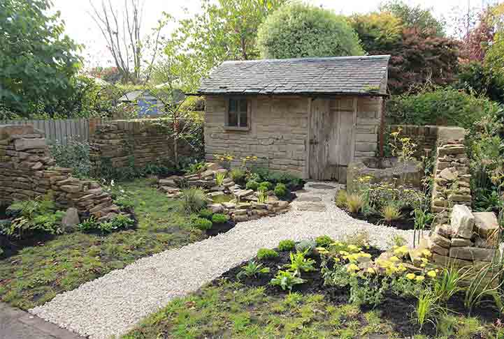 Garden shed with planted flowers around it