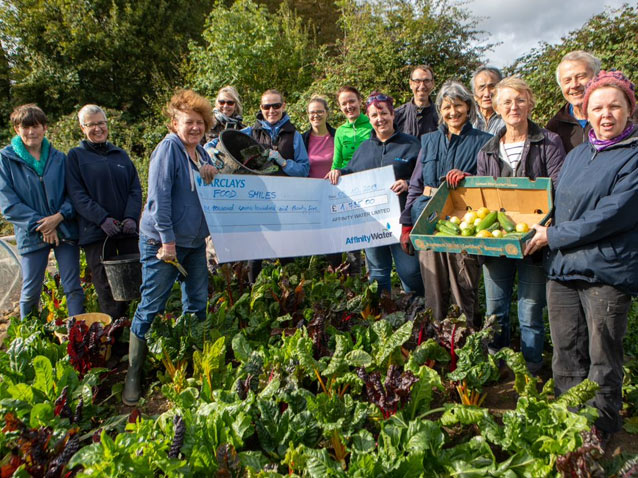 Members of FoodSmiles and Affinity Water employees holding up the cheque