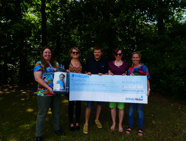 The education team holding the WaterAid cheque.